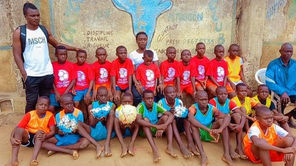Un grup de nens ivorians, amb els seus tècnics, posen amb roba i pilotes arribades des de Mollerussa.
