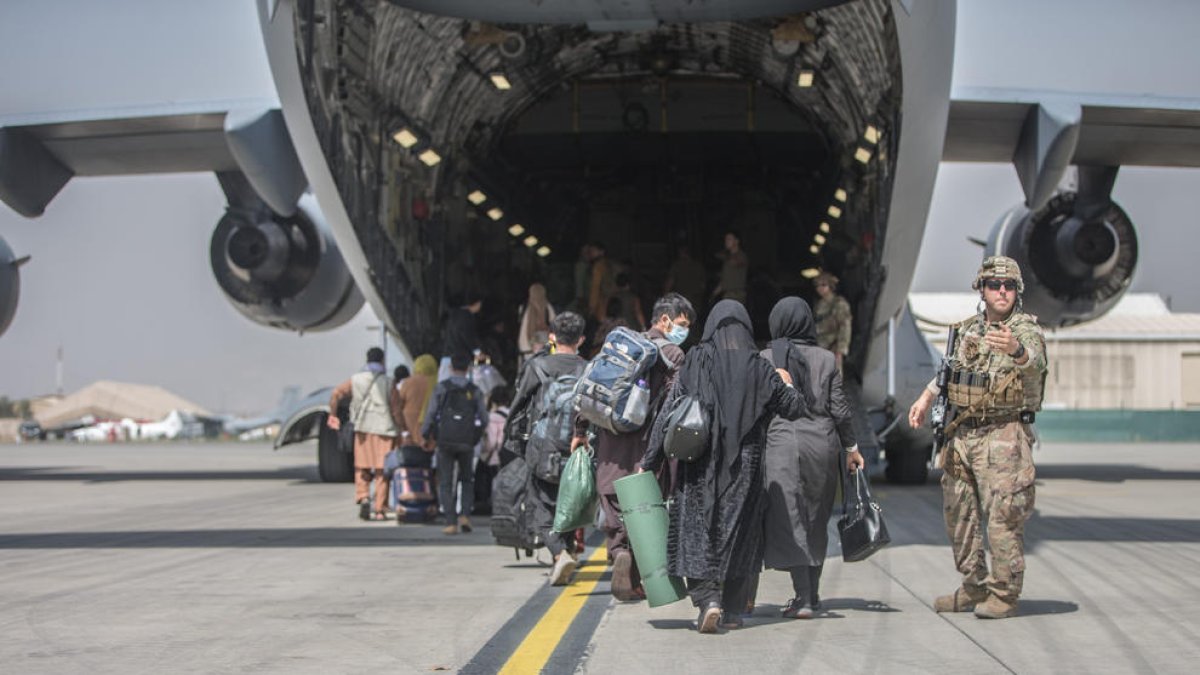 Ciutadans afganesos a punt d’embarcar en una aeronau nord-americana que els allunyi de la barbàrie talibana.