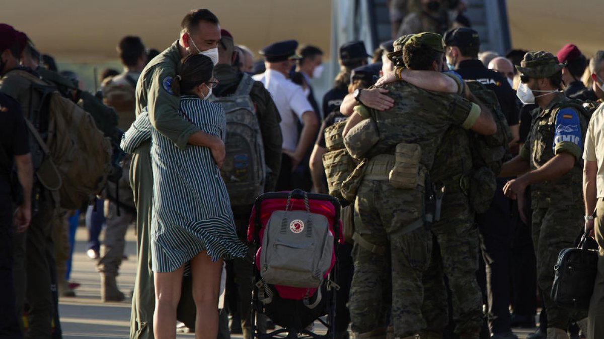 Abrazos a pie de pista entre soldados repatriados y familiares, ayer, en la base de Torrejón de Ardoz.