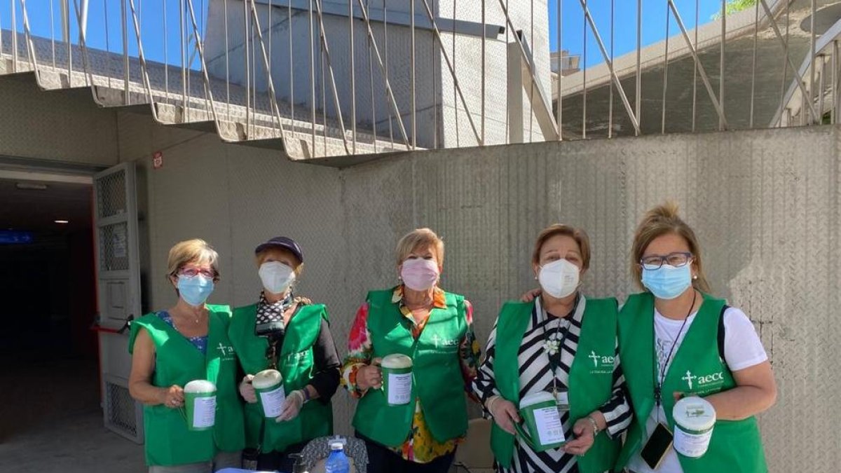 Voluntarias con las huchas verdes de la entidad, el martes.