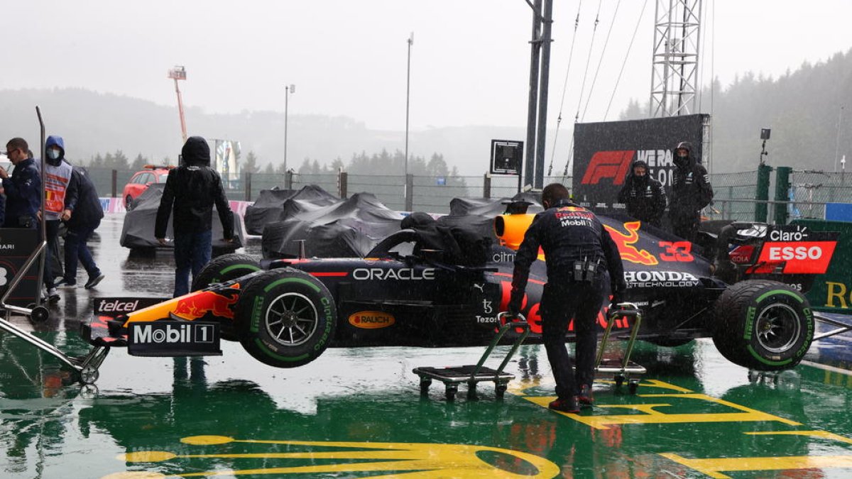 Els mecànics de Verstappen cuiden el vehicle del neerlandès durant l’aturada per la pluja.