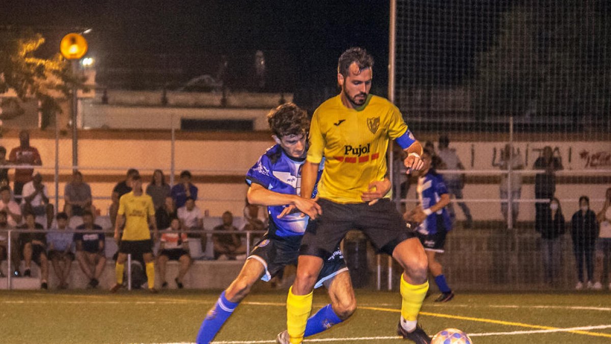 El capitán del Mollerussa protege el balón ante el acoso de un jugador del Solsona.