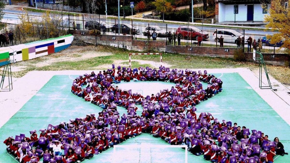 Imatge d'arxiu dels alumnes d'un col·legi formant un llaç contra la Violència de Gènere.