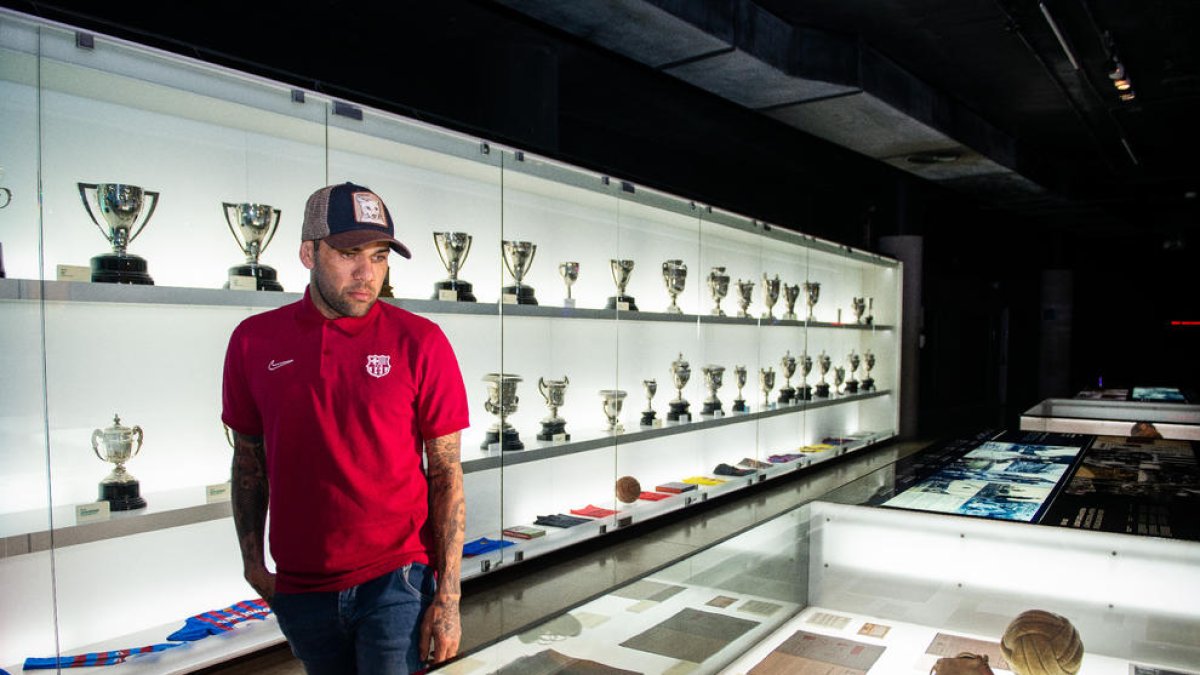 Dani Alves imita Messi en la seua visita al Museu del Barça - Dani Alves va visitar ahir el Museu del Barça, en el qual es troben els 23 títols que va conquerir com a blaugrana. El brasiler es va colar entre les Pilotes d’Or de Messi i va recr ...