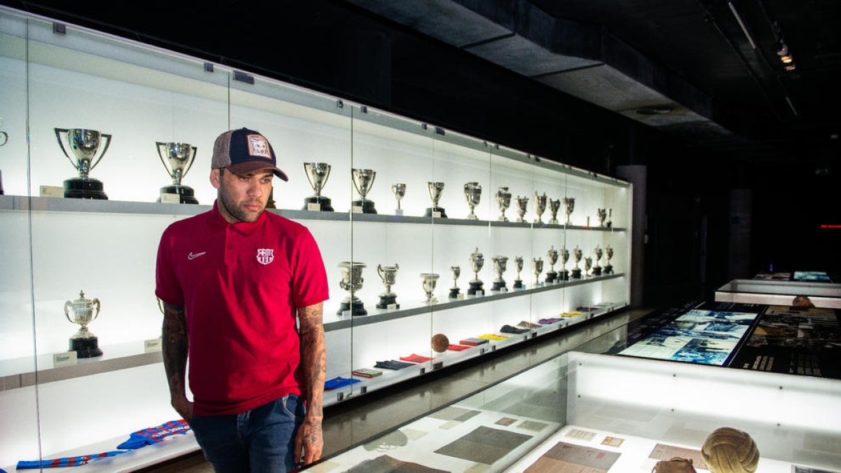 Dani Alves imita a Messi en su visita al Museu del Barça - Dani Alves visitó ayer el Museu del Barça, en el que se encuentran los 23 títulos que conquistó como azulgrana. El brasileño se coló entre los Balones de Oro de Messi y recreó una d ...