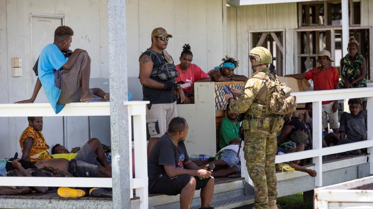 Un militar australià conversa amb diversos ciutadans.