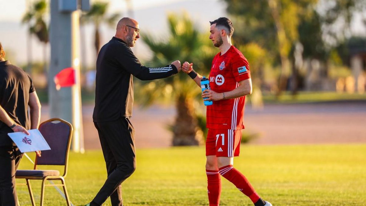 Enric Bernat se saluda con un miembro del cuerpo técnico del equipo canadiense.