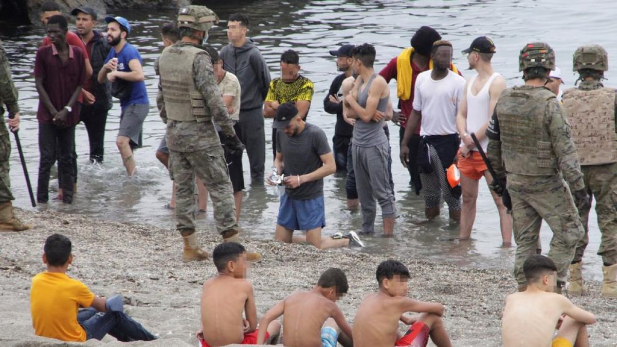 Menors asseguts a la platja a l’arribar a Ceuta la setmana passada.