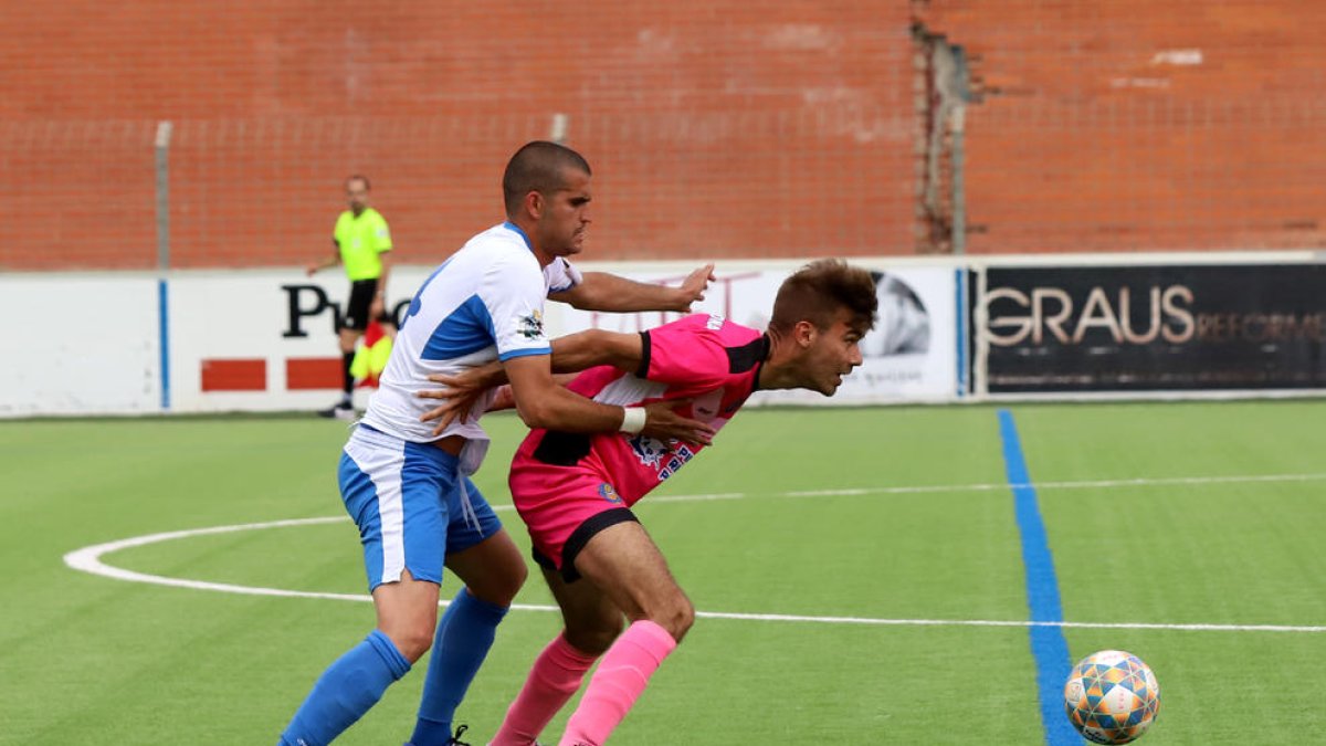 Un jugador del Solsona protege el balón ante el marcaje de uno del Mollerussa.