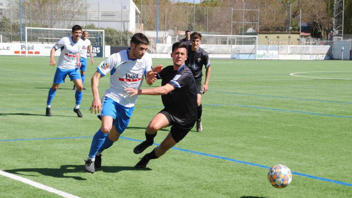 Un jugador del Mollerussa arranca en velocitat cap a la pilota mentre un rival intenta impedir el seu avanç.