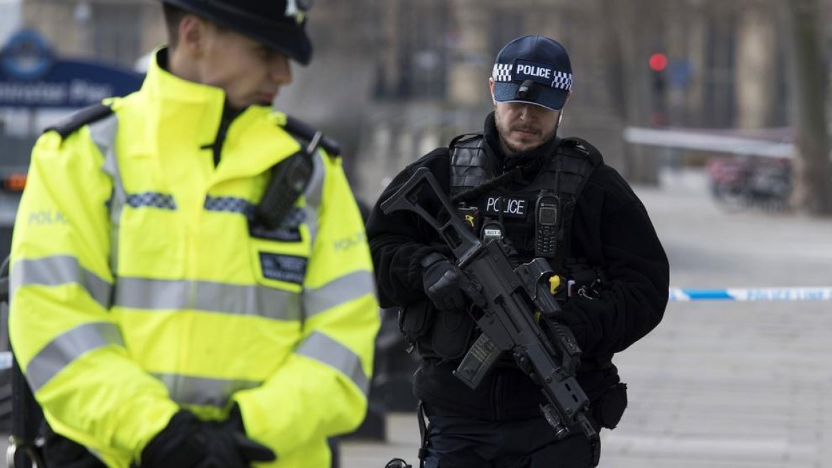 Una pareja de policías fuertemente armados patrullan por las calles de Londres.