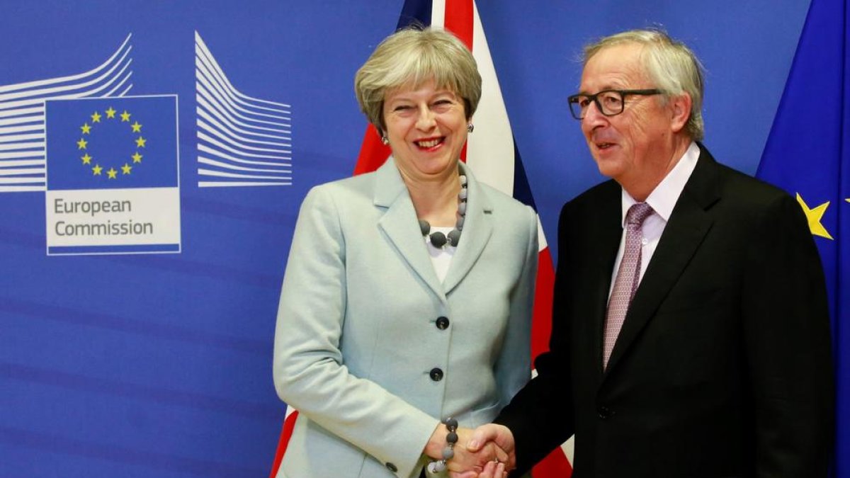 La primera ministra británica, Theresa May y el presidente de la Comisión Europea, Jean-Claude Juncker, se dan la mano antes de la reunión.