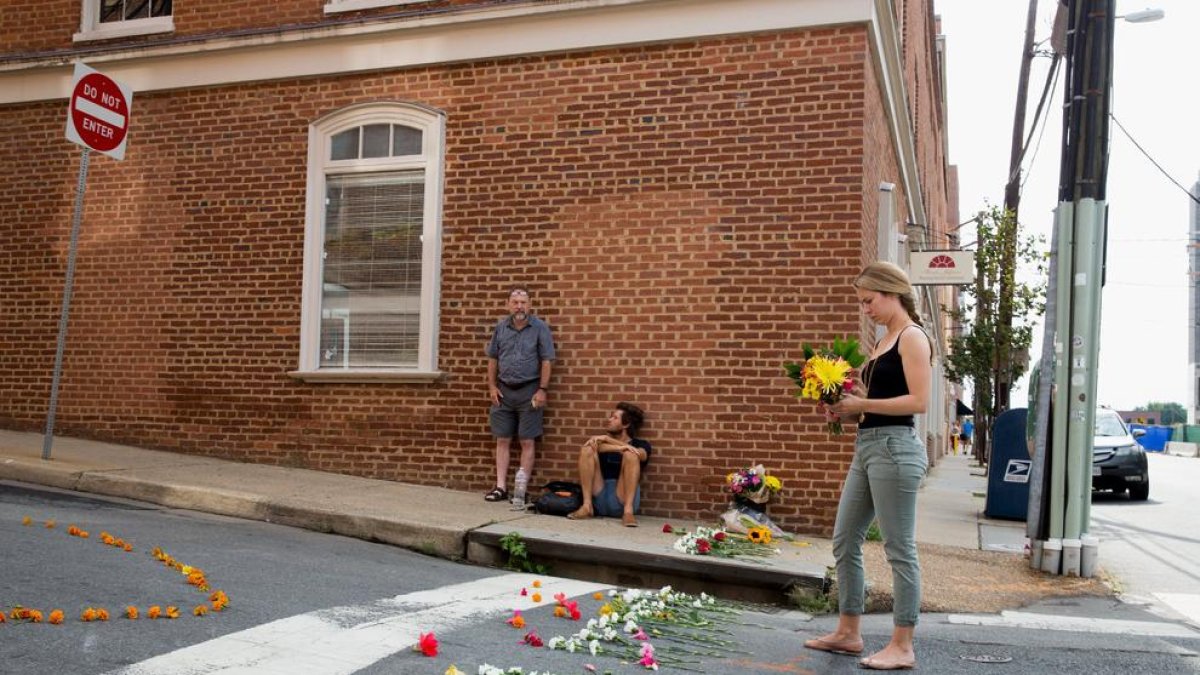 Una joven deposita flores en el lugar del atropello mortal en Charlottesville (Virginia).