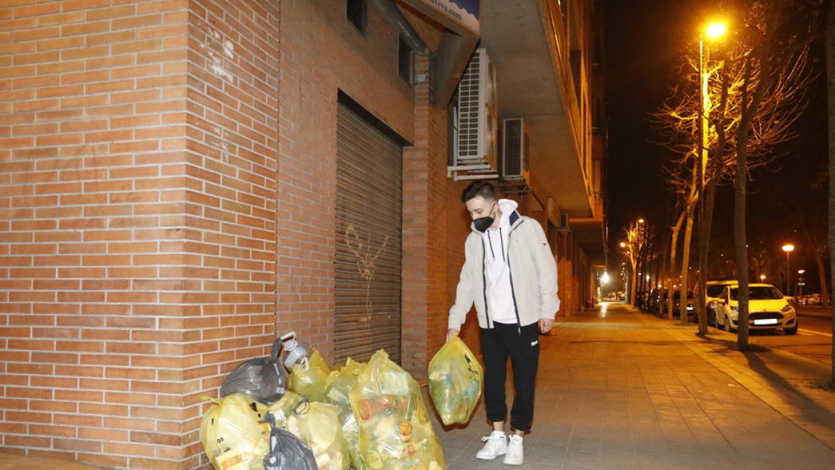 Una vecina de Ciutat Jardí recicla su basura en varios contenedores clasificados por fracciones. 