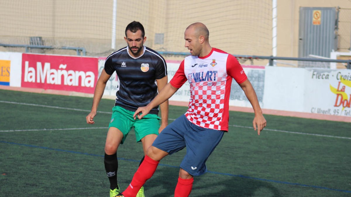 Adrià, que va estrenar el seu caseller golejador, controla la pilota davant la pressió d’un jugador del Martinenc.