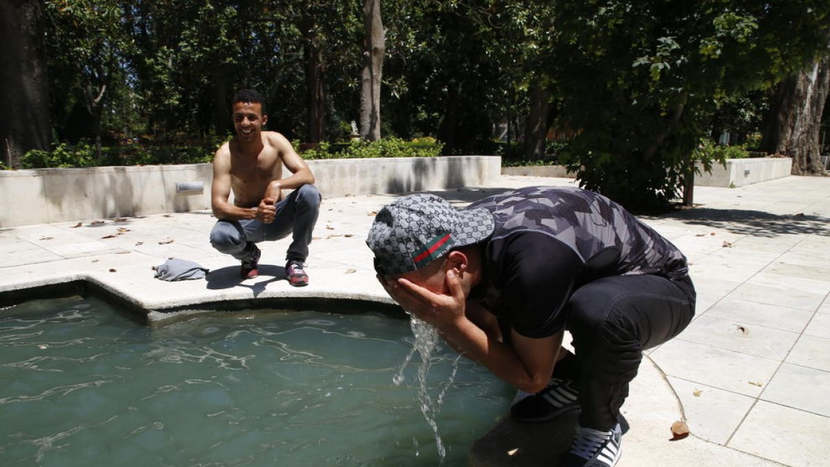 Dos jóvenes se refrescaban ayer en una fuente de Cappont.