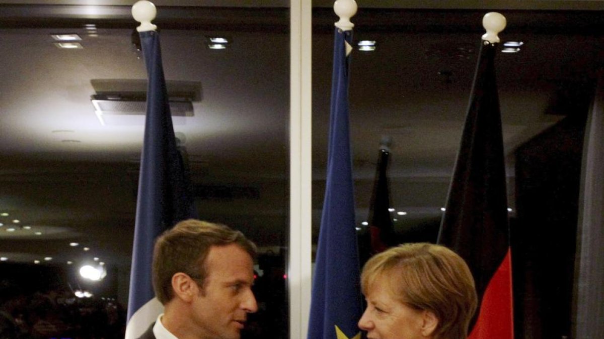 Angela Merkel i Emmanuel Macron conversen durant una reunió ahir a Tallinn.