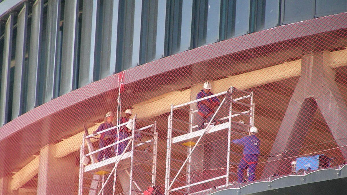 Treballadors en plena jornada laboral en una obra en construcció.