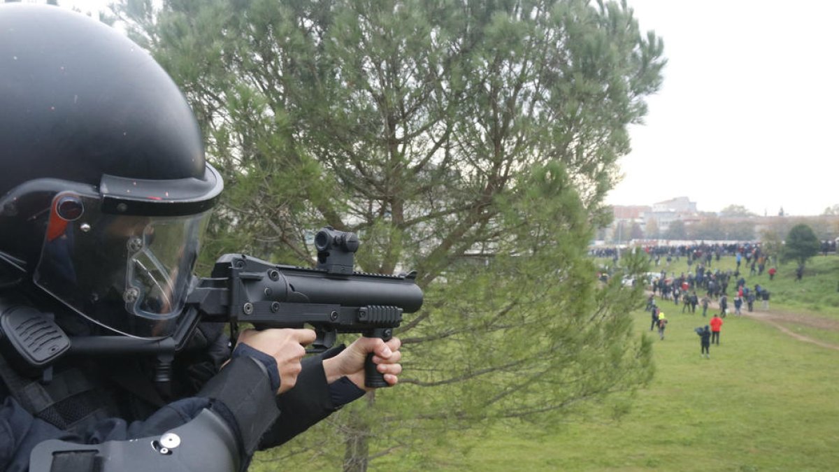 Un mosso apuntant amb una pistola de projectils de foam.