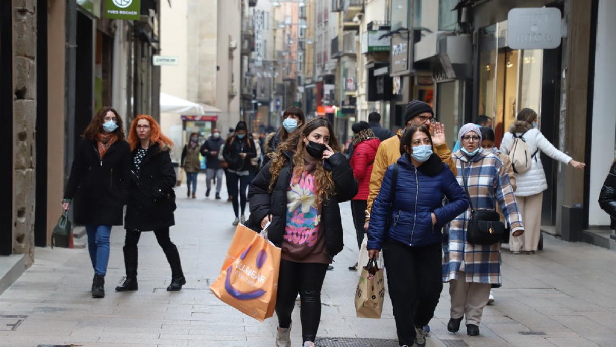 Diversos lleidatans amb i sense màscara passegen per l’Eix Comercial.