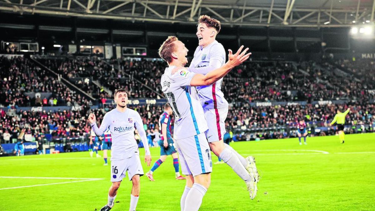 Luuk de Jong, autor del gol de la victoria azulgrana, se abraza con Gavi ante Pedri, ayer en el partido ante el Levante.