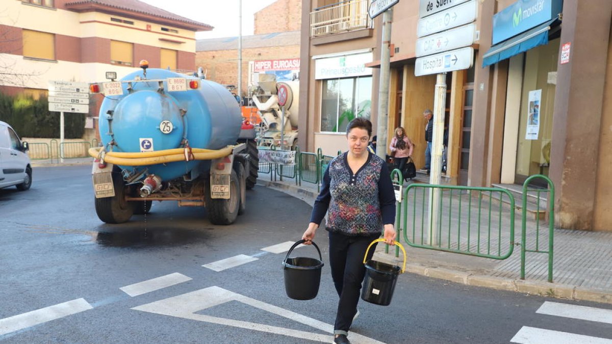 Una veïna recollint ahir aigua de la cisterna que va arribar a Tremp.