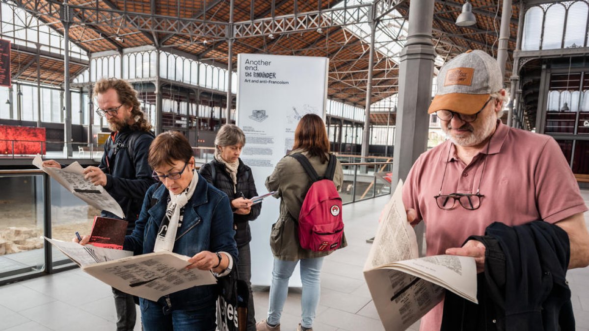 Visitants de la nova exposició d’El Born de Barcelona, amb exemplars de l’obra de Guillem Viladot.