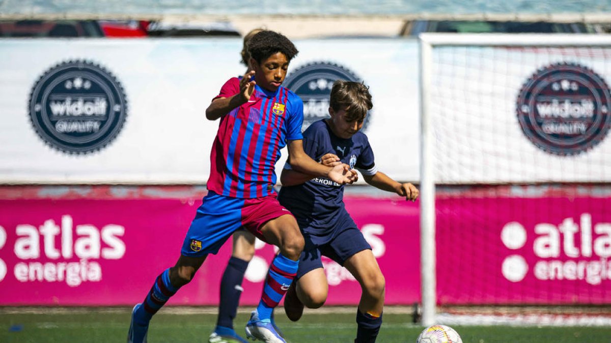 Un jugador del Barça i un de l’Atlètic Lleida pugnen per una pilota en l’edició de l’any passat.