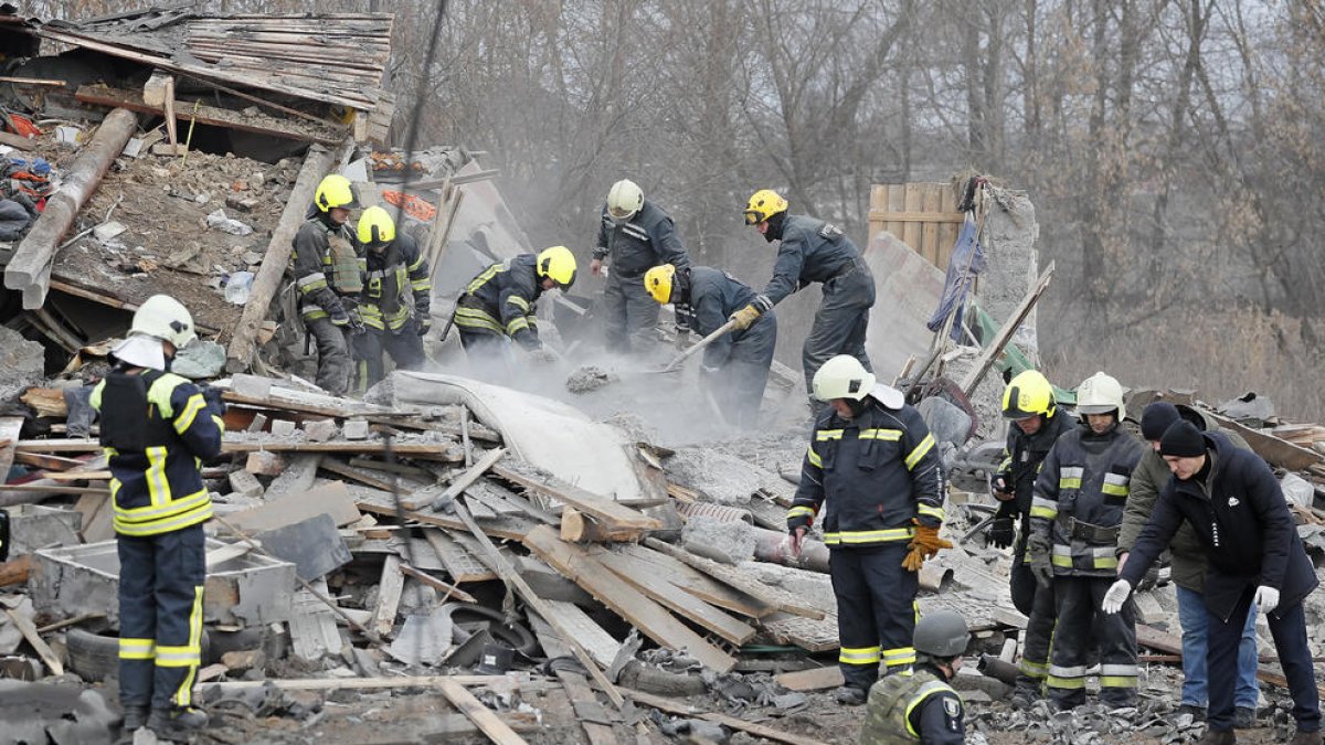 Bomberos buscando víctimas tras un ataque en Kiev.