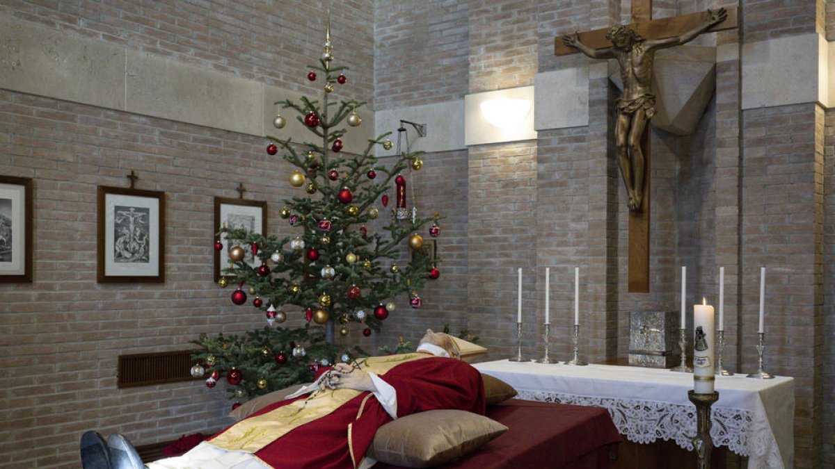 El papa emérito reposa en el monasterio Mater Ecclesiae, con la casulla roja pontificia pero sin palio. 