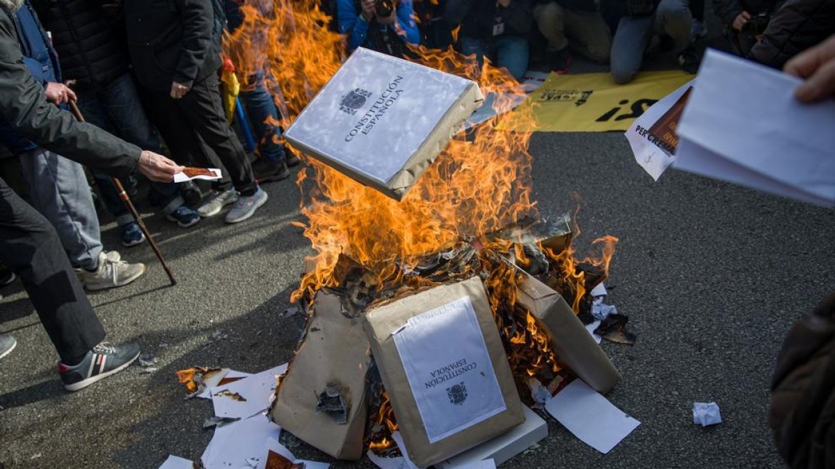 Una hoguera donde se queman constituciones y banderas de España durante una concentración de CDR este martes contra la reforma del Código Penal en Barcelona.