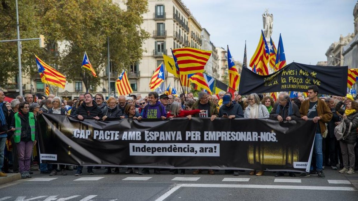 Desenes de persones amb banderes de l'estelada i una pancarta encapçalen una manifestació de l'ANC a Barcelona contra la reforma del Codi Penal.