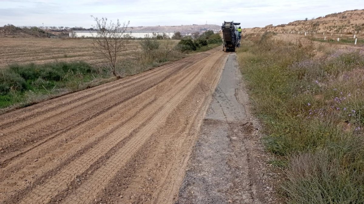 Trabajos para convertir en camino de tierra un tramo de la carretera de Castelldans a Cervià (izquierda) e imagen del mal estado que presenta la calzada. 