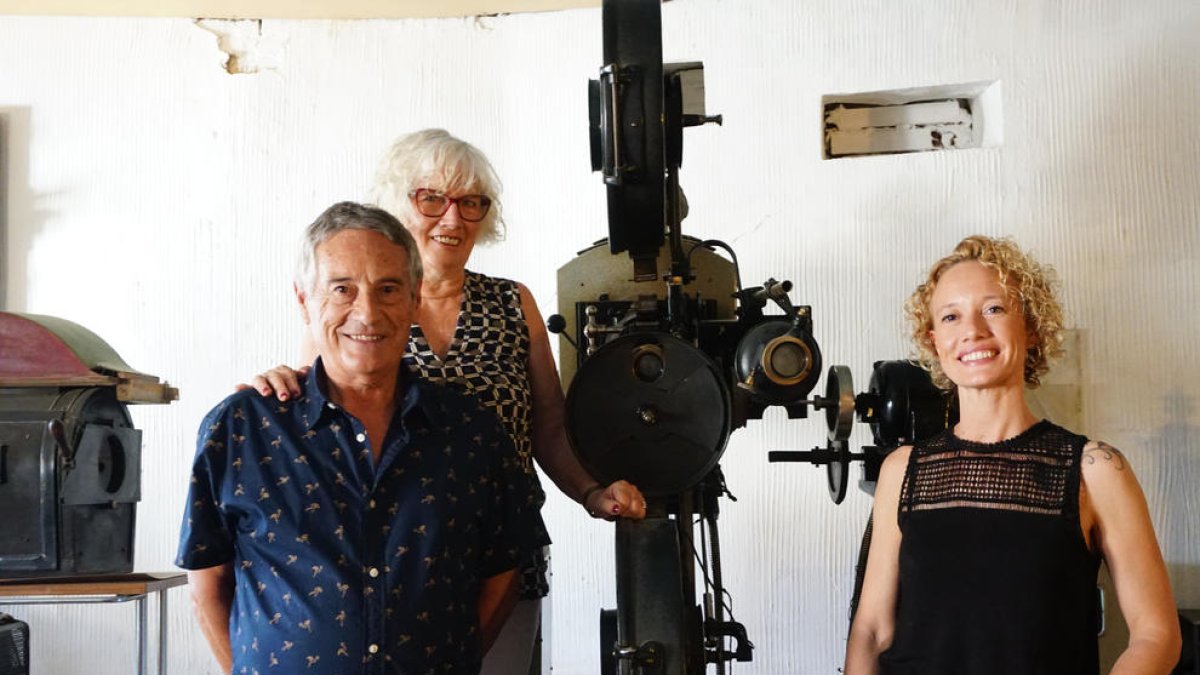 El matrimonio Antoni Ruera y Anna Casteràs y su hija, Diana Ruera, junto a un proyector de Cal Marina.