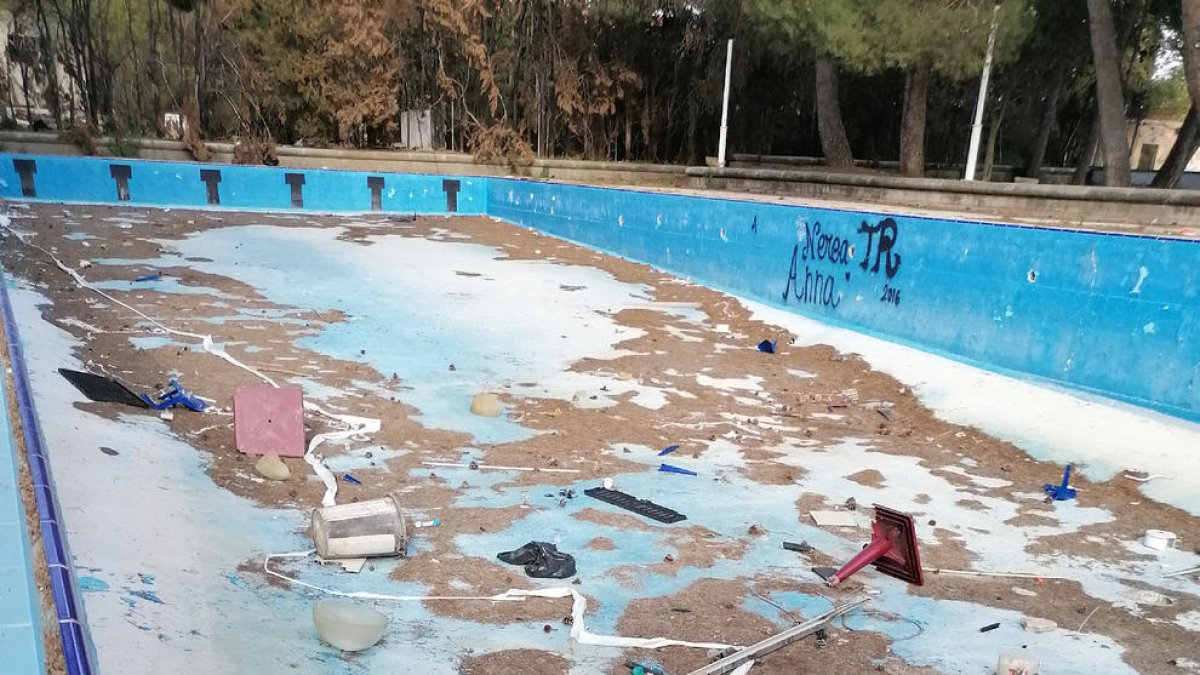 Restos de vegetación seca y desperdicios en la piscina infantil.