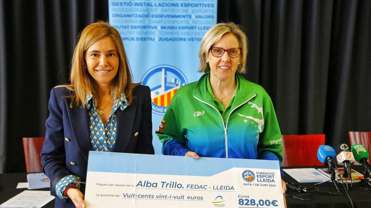 Marta Pereira haciendo entrega del cheque para la gimnasta a la directora del FEDAC, Maribel Moncasí.