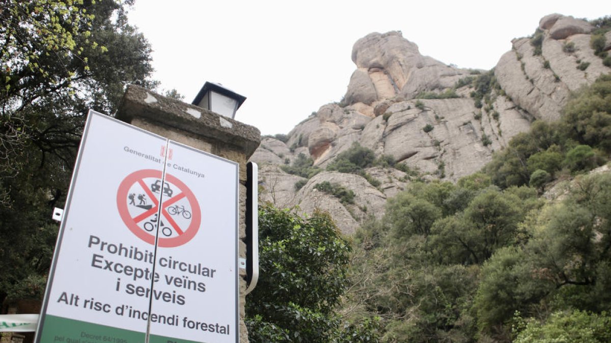 Un cartell senyalitza la prohibició d’accés al Parc Natural de Montserrat pel risc d’incendi.