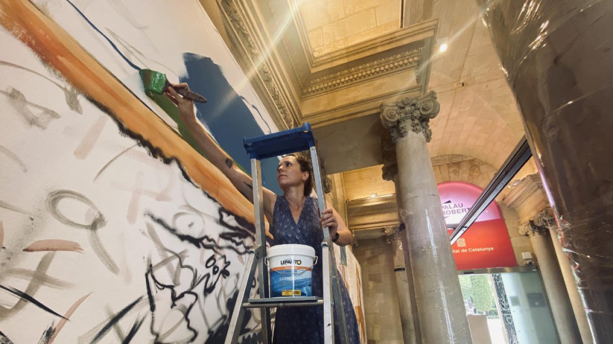 L’artista lleidatana Lily Brick va pintar ahir un mural en la inauguració de l’exposició al Palau Robert.