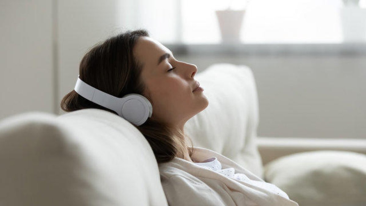 Una mujer durmiendo mientras escucha música con auriculares.