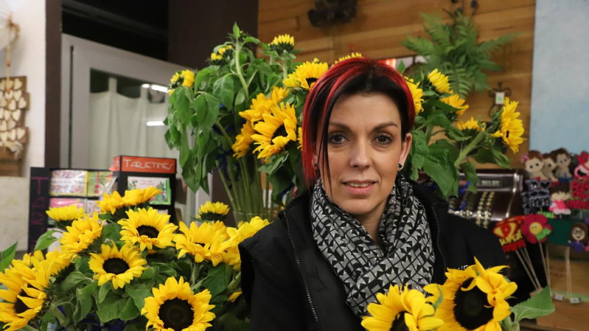 Natalia Rodríguez, de Flaires Dissenys Florals, sosteniendo dos girasoles solidarios.