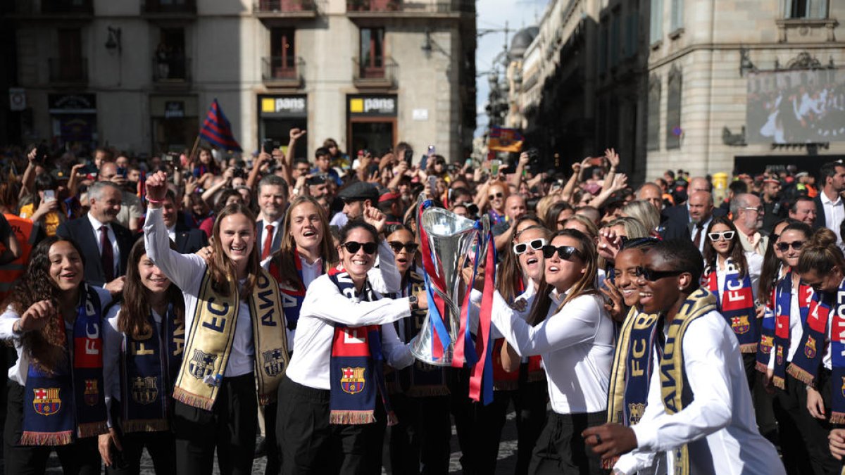 Jugadores del Barça, ahir a la plaça Sant Jaume, mostrant la Champions que van guanyar dissabte davant de l’afició blaugrana.