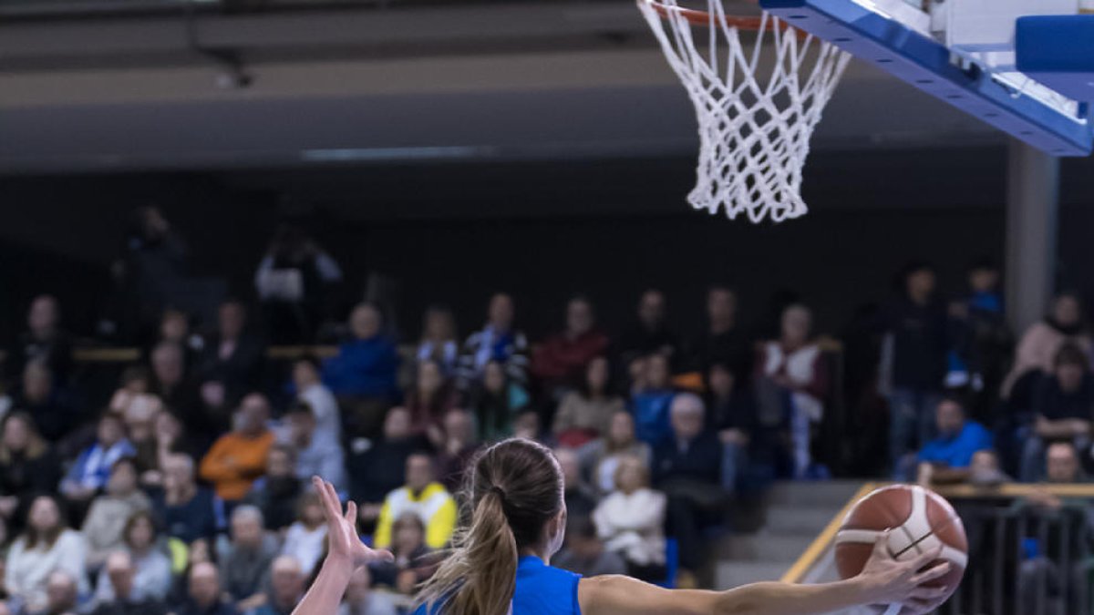 Laura Peña busca una compañera a la que pasar el balón ante Andela Delic.