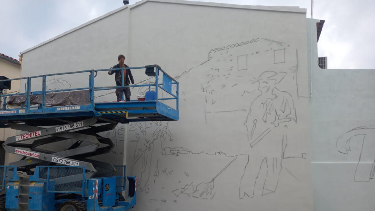 Oriol Arumí, vora el mural que va començar a pintar ahir a la placeta Mossèn Amadeu de Torrelameu
