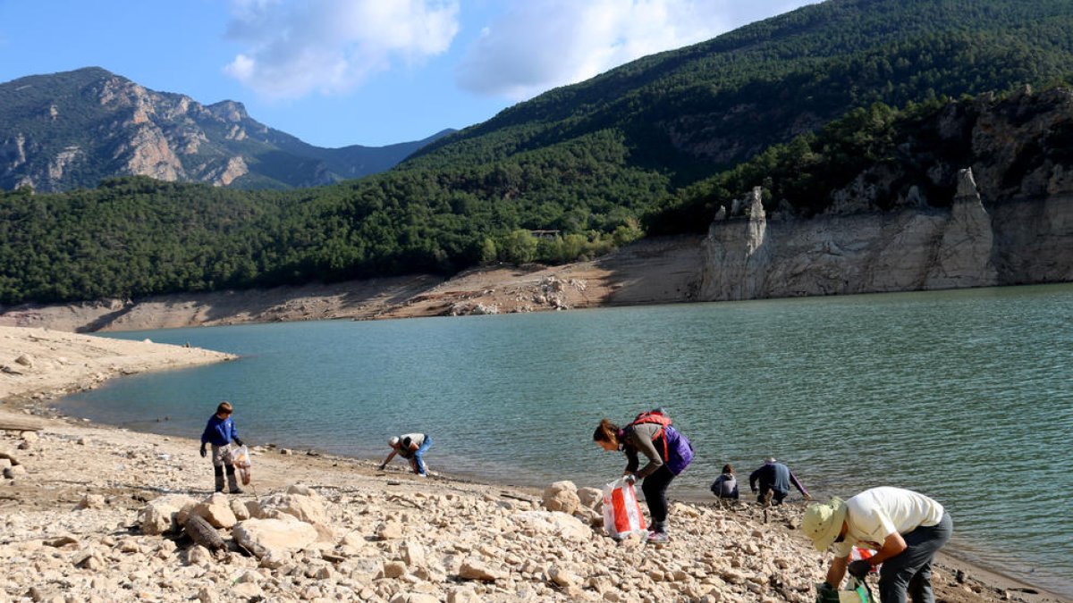 Un grup de voluntaris retirant plàstics del pantà d'Oliana, a l'Alt Urgell.