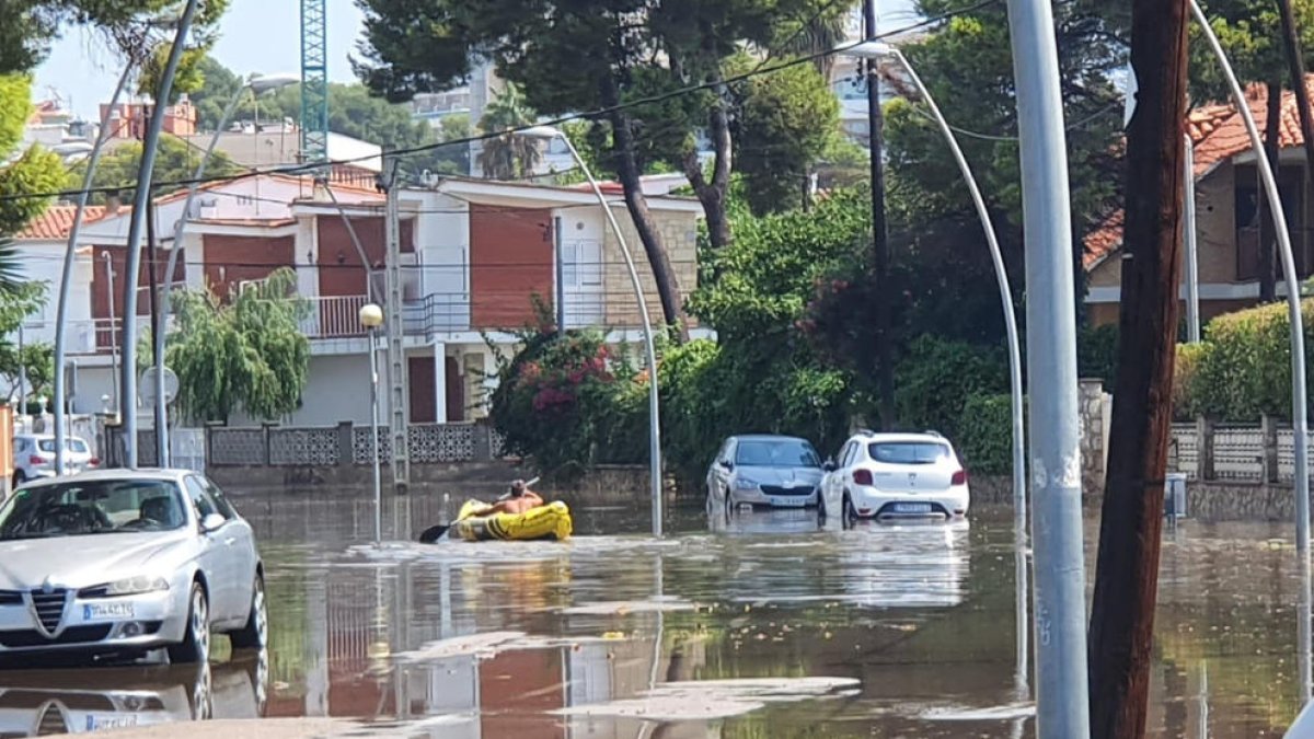 Una piragua navegant dimarts per un carrer inundat de Coma-ruga.