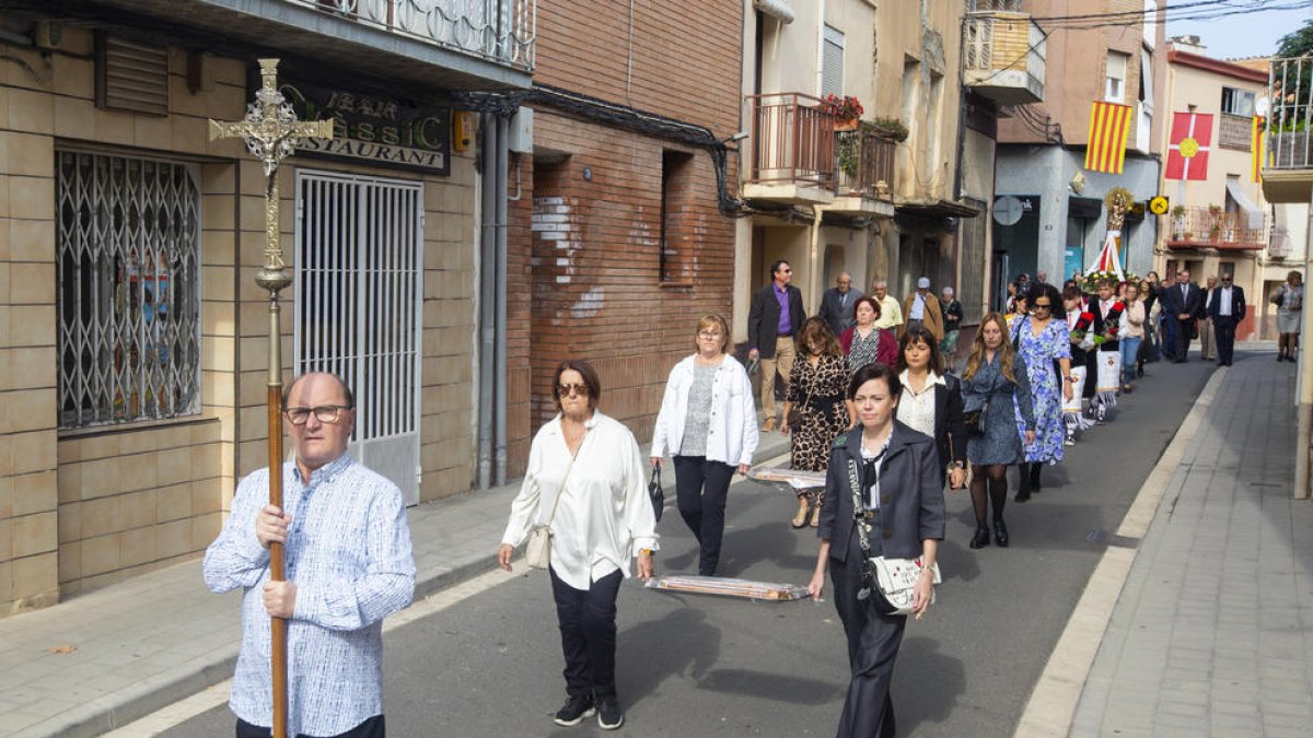 Momento de la procesión con diversos ciudadanos portando el pan bendito por las calles del municipio.