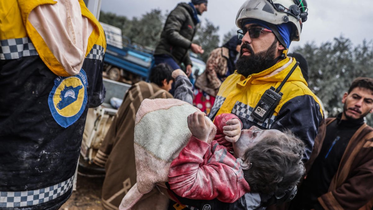 Miembros de los Cascos Blancos sirios llevan el cuerpo de una niña de un edificio destruido en Harem, cerca de la frontera con Turquía.