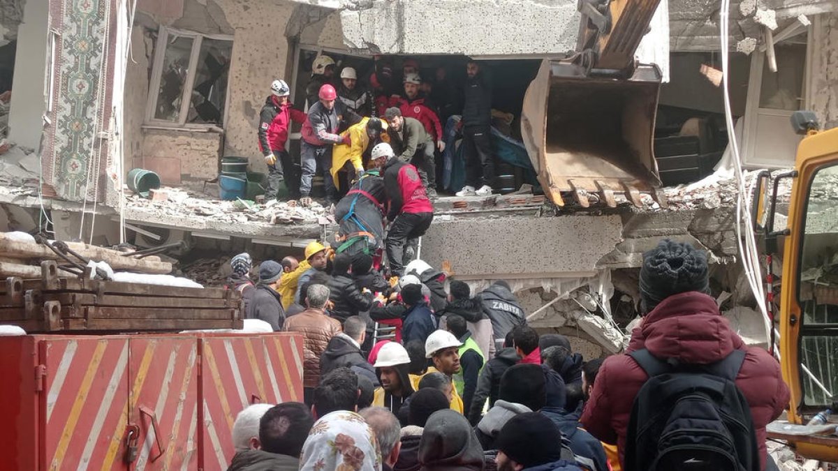 Los equipos de rescate turcos evacúan un cuerpo de entre los escombros de un edificio.