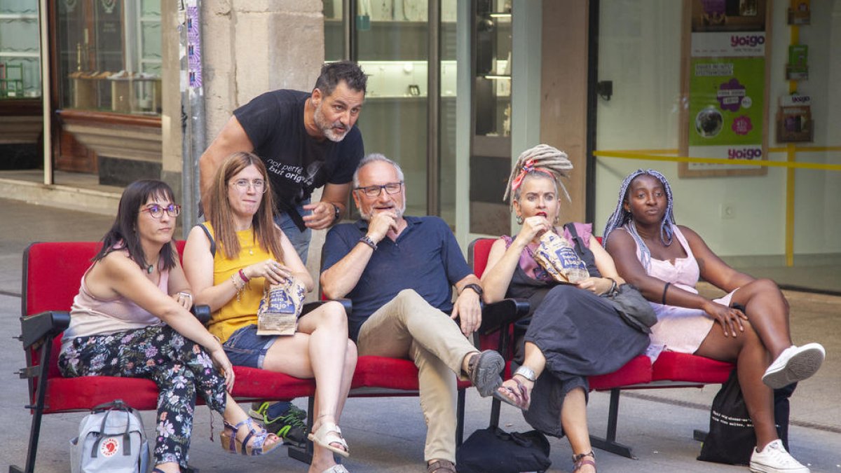 Ferran Orobitg, junto a participantes en su proyecto ‘Opia’ sentados en butacas en medio de la calle.