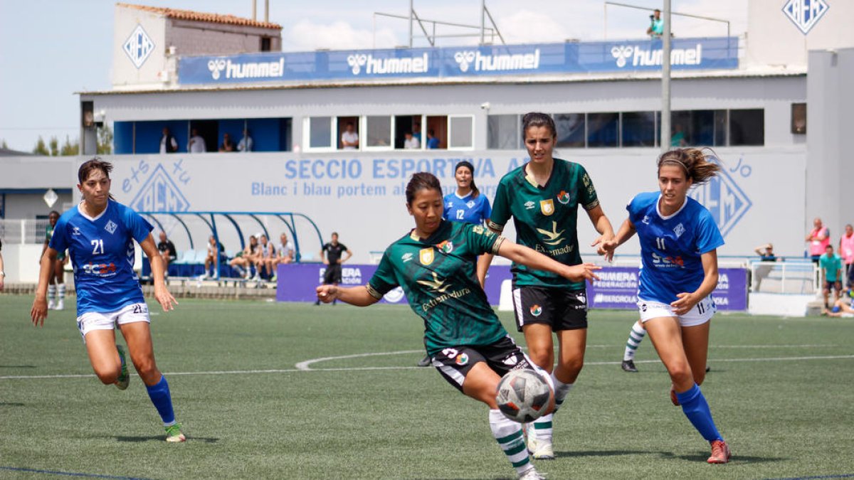 Laura Fernández i Mariajo observen com la visitant Yoshimura prova d’aclarir una pilota.